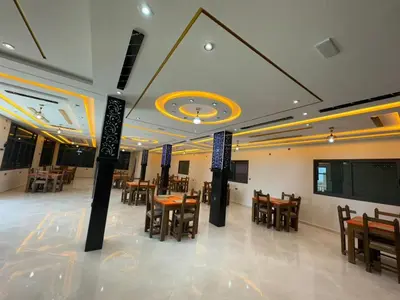 a dining room with tables and chairs and a projection screen at Cafe Restaurant Moove Oil in Rissani