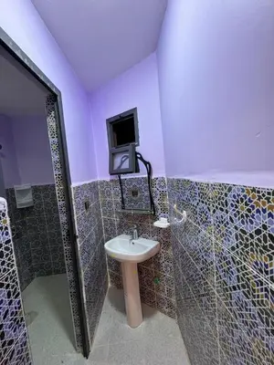 a bathroom with a sink and a tv on the wall at Cafe Restaurant Moove Oil in Rissani