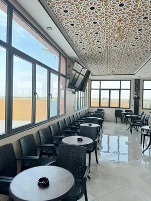 a dining room with tables and chairs and windows at Cafe Restaurant Moove Oil in Rissani