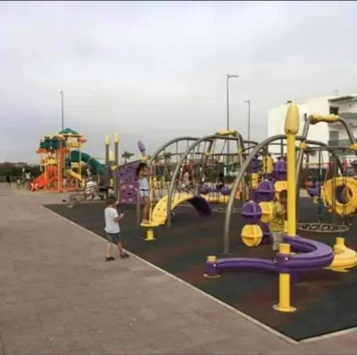 a child standing in front of a playground at Sidi rahal Blanca beach in Zaouia Sidi Rahkal