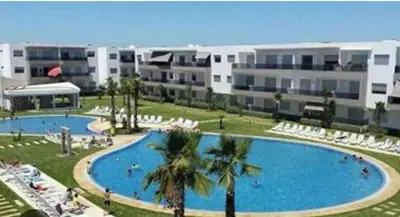 a large swimming pool in front of a building at Sidi rahal Blanca beach in Zaouia Sidi Rahkal