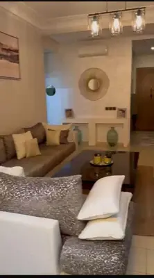 a living room with a couch and a table at Sidi rahal Blanca beach in Zaouia Sidi Rahkal