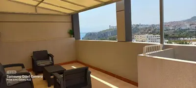 a room with chairs and a view of the city at Appartement vue mer quartier port 4 in Oulad Akkou