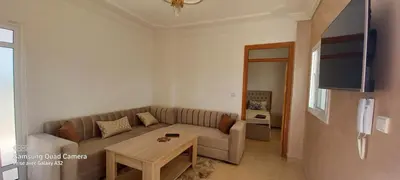 a living room with a couch and a table at Appartement vue mer quartier port 4 in Oulad Akkou