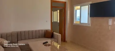 a living room with a couch and a window at Appartement vue mer quartier port 4 in Oulad Akkou