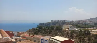 a view of a city with the ocean in the background at Appartement vue mer quartier port 4 in Oulad Akkou