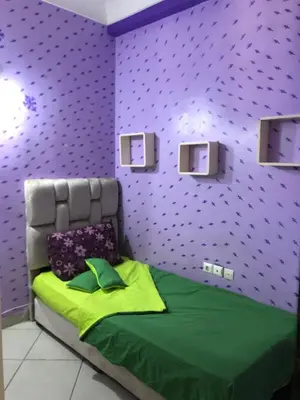 a bedroom with a green bed with purple walls at مارتيل in Oulad Akkou