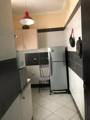 a kitchen with a refrigerator and a chair in it at مارتيل in Oulad Akkou