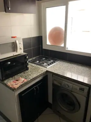 a kitchen with a stove and a washing machine at مارتيل in Oulad Akkou