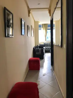 a hallway with a red chair and a living room at مارتيل in Oulad Akkou