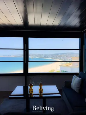 a living room with a couch and a table at Luxurious penthouse with sea view in Oulad Akkou