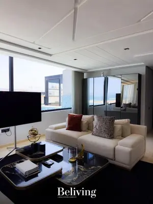 a living room with a couch and a table at Luxurious penthouse with sea view in Oulad Akkou