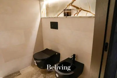 a bathroom with a black toilet and a sink at Luxury, private pool and sea view in Oulad Akkou