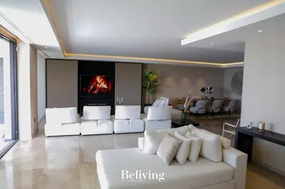a living room with a white couch and a fireplace at Luxury, private pool and sea view in Oulad Akkou