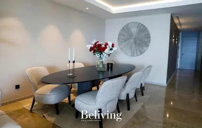 a dining room table with chairs and a vase of flowers at Luxury, private pool and sea view in Oulad Akkou