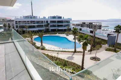 an overhead view of a swimming pool with palm trees and a building at Luxury, private pool and sea view in Oulad Akkou