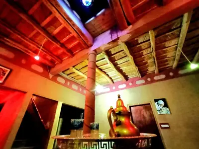 a room with a table with a vase in it at Gite le Calme café Restaurant Pizzeria in Bou Tharar