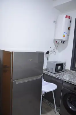 a kitchen with a refrigerator and a toaster oven at Cozy Apartment close to amenities in Fès