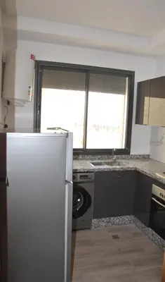 a kitchen with a refrigerator and a washing machine at Cozy Apartment close to amenities in Fès