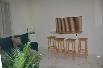 a living room with a table and four stools at Cozy Apartment close to amenities in Fès