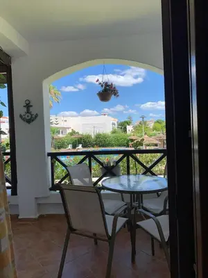 a balcony with a table and chairs and a window at Chic appartement costa cabo in Oulad Akkou