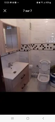 a bathroom with a white toilet and a sink at résidence ichraka in Oulad Akkou