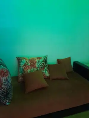 a couch with pillows on it in a room at résidence ichraka in Oulad Akkou