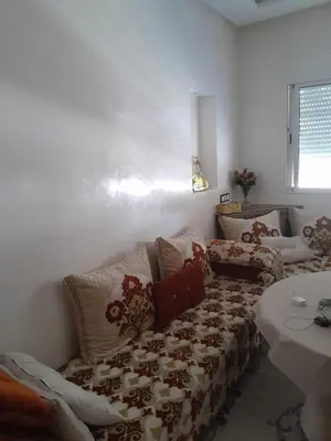 a living room with a couch and a table at résidence ichraka in Oulad Akkou