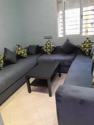 a living room with a couch and a coffee table at résidence ichraka in Oulad Akkou