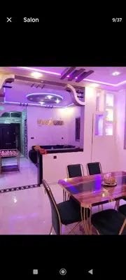 a dining room with a table and chairs and a bar at تجزئة الباهية in Meknès