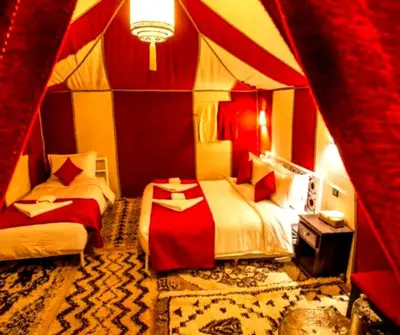 a room with two beds in a tent at Merzouga Hosting & Camelride in Merzouga