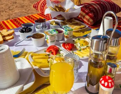 a table with breakfast foods and drinks on it at Merzouga Hosting & Camelride in Merzouga