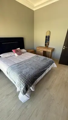 a bedroom with a large bed and a desk at Taghazout Bay Villa AMDA in Oulad Akkou