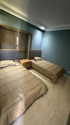 two beds in a room with blue walls at Taghazout Bay Villa AMDA in Oulad Akkou