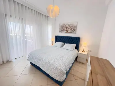 a bedroom with a bed with a blue headboard at La perle bleue de Beralmar Asilah in Oulad Akkou