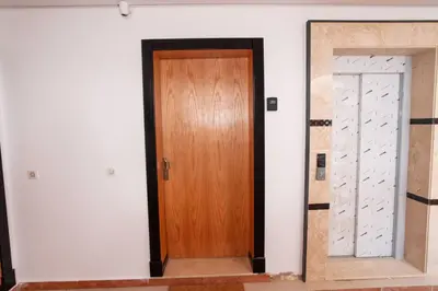 a hallway with a wooden door in a room at La perle bleue de Beralmar Asilah in Oulad Akkou