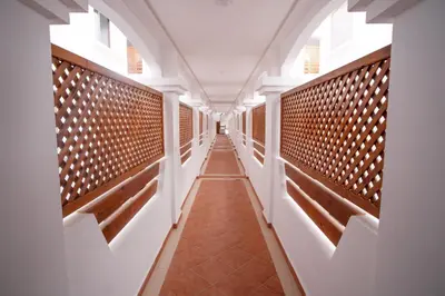 a corridor in a building with white walls and brown tiles at La perle bleue de Beralmar Asilah in Oulad Akkou