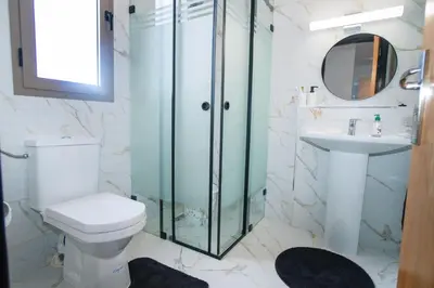 a bathroom with a shower and a toilet and a sink at La perle bleue de Beralmar Asilah in Oulad Akkou