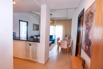 a living room with a kitchen and a dining room at La perle bleue de Beralmar Asilah in Oulad Akkou