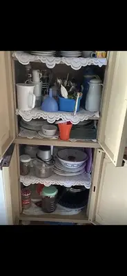 a cabinet filled with dishes and utensils at Apartment a louer sur targha tetouan in Oulad Akkou