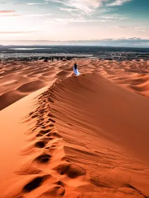 a person standing on top of a sand dune at Merzouga Eastern Camp Luxury in Merzouga