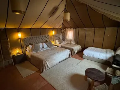 a bedroom with two beds in a tent at Merzouga Eastern Camp Luxury in Merzouga