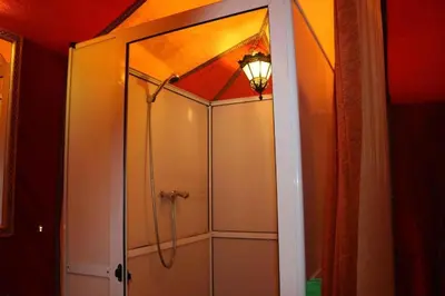 a bathroom with a shower with a glass door at Azul desert camp in Merzouga