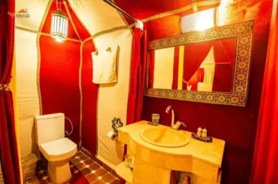 a red bathroom with a toilet and a sink at Azul desert camp in Merzouga