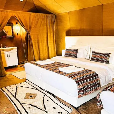 a large bed in a room with a sink at Azul desert camp in Merzouga