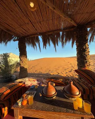 a table in the desert with utensils on it at Happy luxury camp in Merzouga
