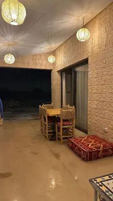 a dining room with a table and chairs and lights at Villa Azoul in Tiguemmi n Oumzil et Tnine