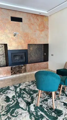 a living room with a fireplace and a blue chair at Villa Azoul in Tiguemmi n Oumzil et Tnine
