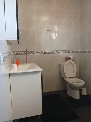 a bathroom with a white toilet and a sink at appartement duplex a saidia in Oulad Akkou