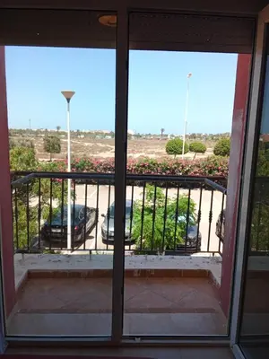a window view of a parking lot from a balcony at appartement duplex a saidia in Oulad Akkou